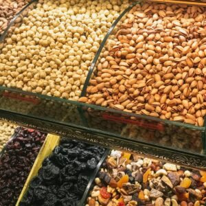 Colorful assortment of nuts and dried fruits in a market display, showcasing healthy snack options.